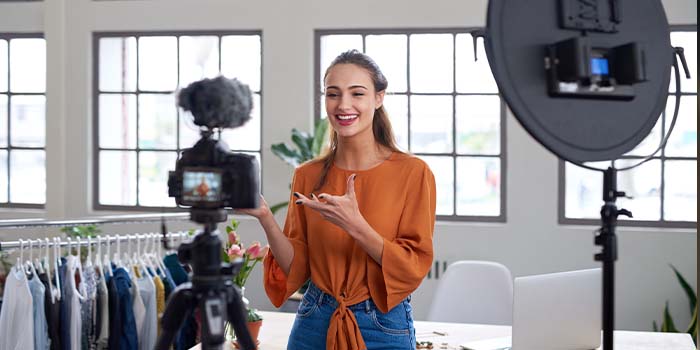 Lady recording a personalized video marketing message on a dslr camera with lighting kit